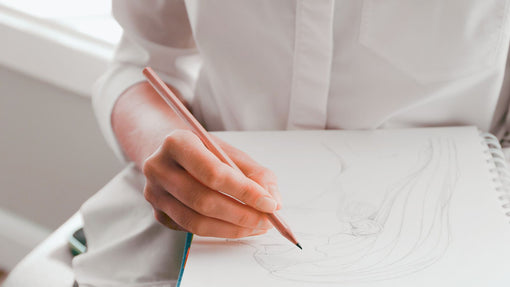 A hand holding a pencil. 