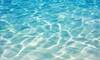 A serene, top down view of aqua blue ocean water featuring gentle, rhythmic ripples and soft on a rolling wave.