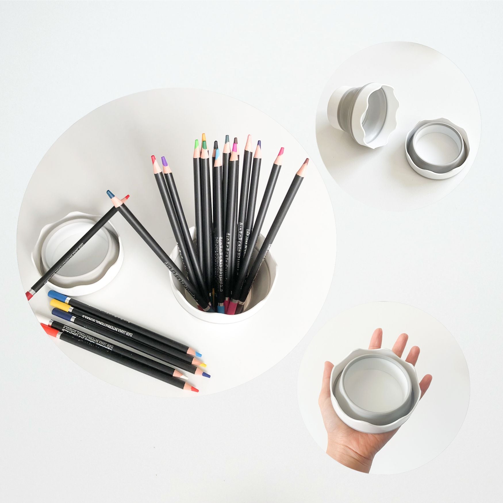 Set of colored pencils on a white surface with a hand holding a small container.