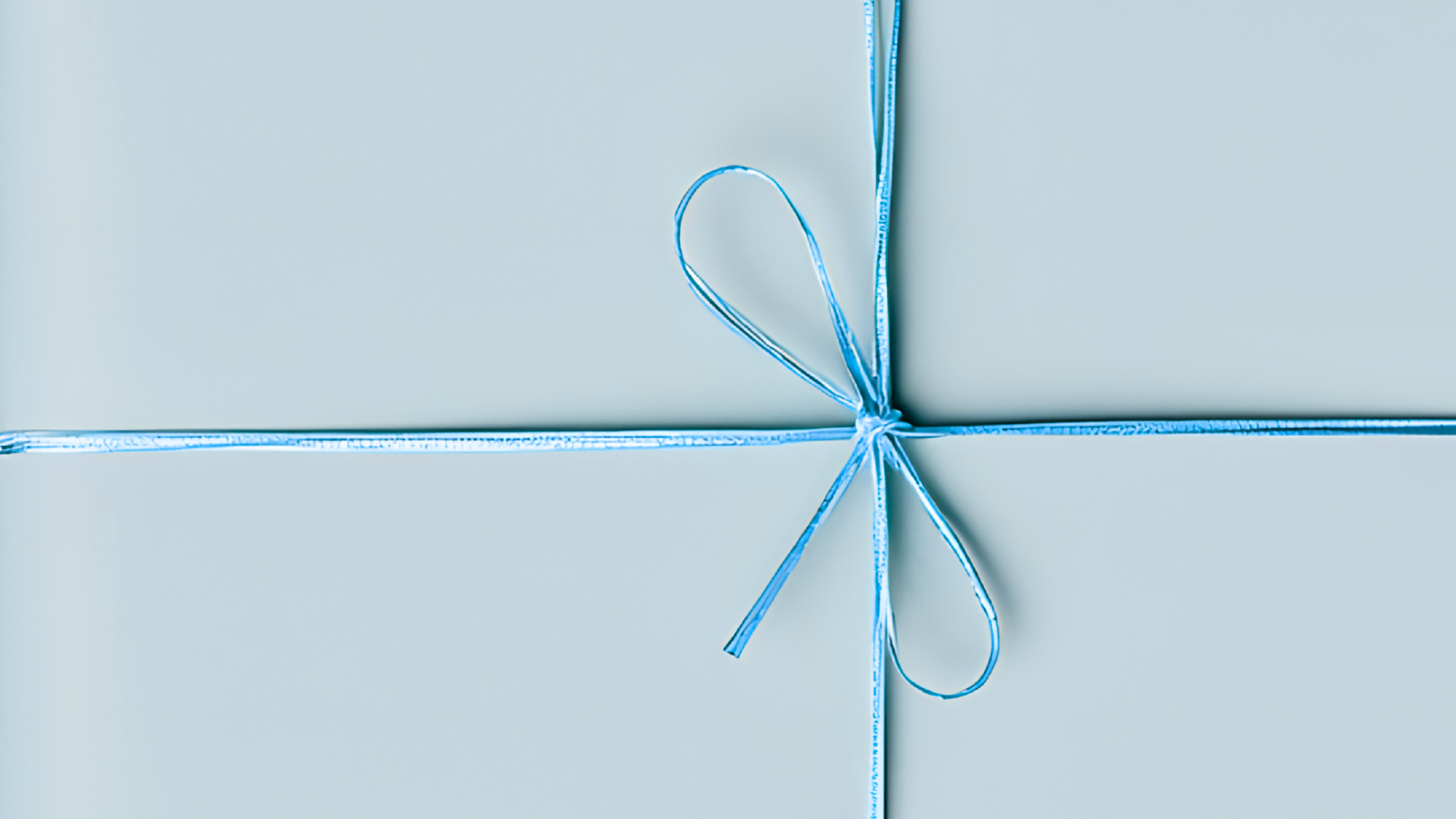 Blue gift box with a bow on a light blue background