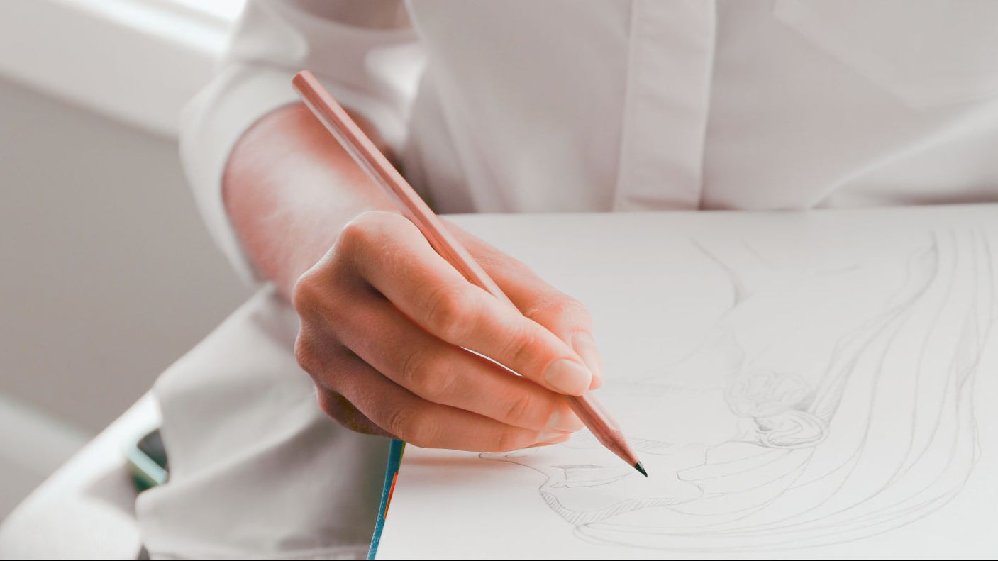 Person writing with a pen on a white surface