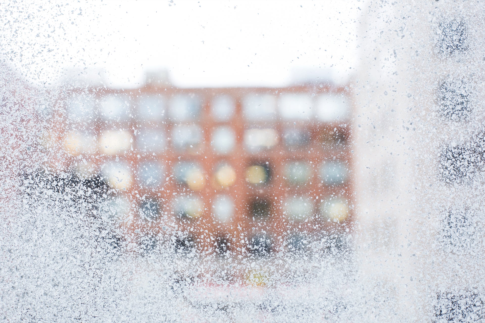 Winter frosted window glass with buildings across the street